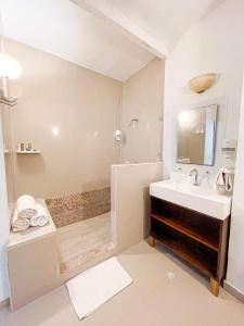 圣安德烈斯可可普拉姆海滩酒店的白色的浴室设有水槽和淋浴。