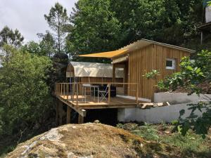 蓬蒂-达巴尔卡Glamping Cabana nas arvores的一座木结构小房子,在树林里设有一个甲板