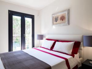 奥尔比亚WLofts 11, 12 & 14 by Klodge的一间卧室配有一张带红色和白色枕头的大床