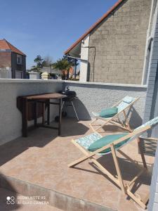 勒克罗图瓦Le Crotoy plage Baie de somme appartement l'Avocette的一个带两把椅子和一张桌子的庭院