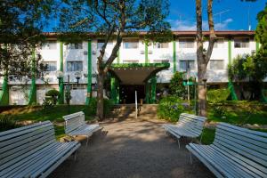 阿蒂巴亚Eldorado Atibaia Eco Resort的大楼前的三个公园长椅