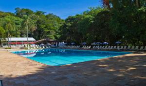阿蒂巴亚Eldorado Atibaia Eco Resort的一个带椅子和遮阳伞的游泳池