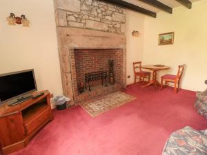 伍勒Rose Cottage的客厅设有壁炉和桌子