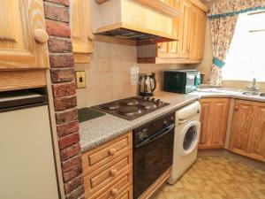 伍勒Rose Cottage的小厨房配有炉灶和洗碗机。
