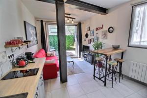 瓦讷Appartement centre-ville avec terrasse INDUS的一间厨房和一间带红色沙发的客厅