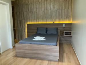 PinhaisMotel Passione的一间卧室配有一张带木制床头板的床