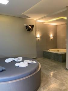 PinhaisMotel Passione的带浴缸的浴室以及带毛巾的床。