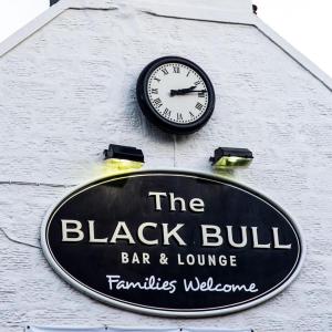 波尔蒙特The Blackbull Inn Polmont的酒吧和休息室标志的边的钟