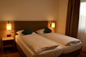 兰纳赫Gasthof Kranerwirt的酒店客房设有两张床和两盏灯。