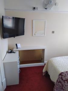 布莱克浦布莱克浦酒店的一间设有床铺和墙上电视的房间