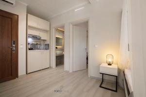 尼坡帝PORTO PORTES suites的白色的走廊,配有桌子和厨房