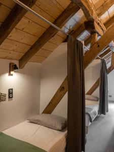 圣米歇尔AUBERGE BORDA的阁楼卧室设有两张床铺和木制天花板