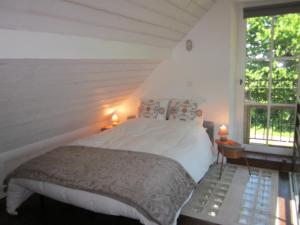 阿姆博斯La Vallière en Vue - gîte avec sauna的一间卧室设有一张大床和一个窗户。