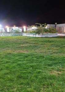 塔伊夫Al Moltaqua Chalet的夜晚在田野上设置的白色围栏