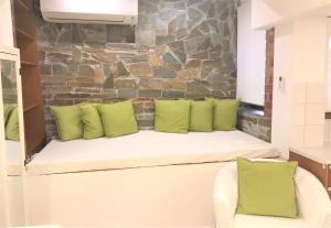 帕拉塔蒙Amaryllis House的客房内的白色长凳和绿色枕头