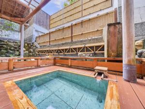 真庭市Yukai Resort Terunoyu的一座位于木甲板上的游泳池,