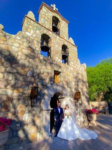 阿拉莫斯哈森达桑托酒店的站在石头建筑前的新娘和新郎
