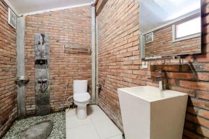 马格朗Balkondes Kenalan的砖砌浴室设有卫生间和水槽