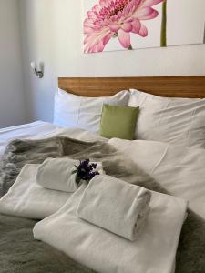 格舍嫩Hotel Weisses Rössli的一张带毛巾和鲜花的白色床