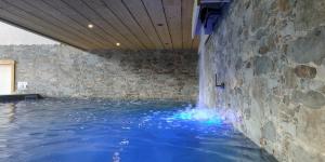 DorénazL Ame et Son du Coeur的石头墙上的蓝色灯光游泳池