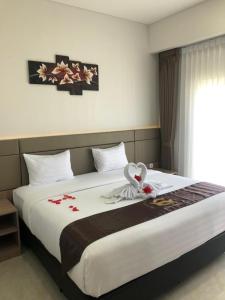 大松巴哇Grand Samota Hotel的一间卧室配有一张带鲜花的大床