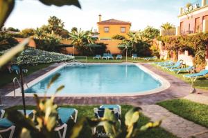 圣玛丽亚港皮诺玛尔酒店的一座带椅子的庭院和一座建筑中的游泳池