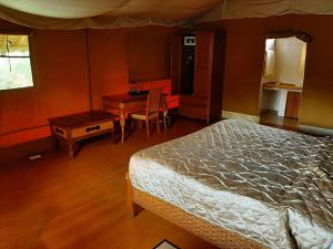 安博塞利安博塞利AA旅舍的一间卧室配有一张床、一张桌子和一张桌子