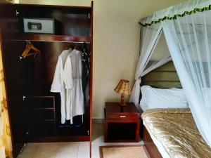 安博塞利安博塞利AA旅舍的一间卧室配有一张天蓬床和一个衣柜