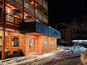 平佐洛Edelweiss Alpine Nature的雪中的一个木头建筑