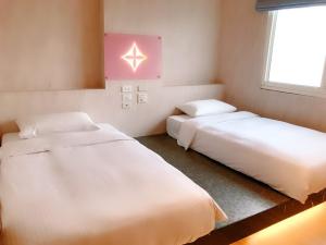 台北沃客商旅 - 成功馆的客房设有两张床和窗户。