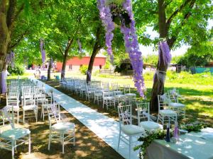 CadèAgriturismo Corte dei Landi的婚礼过道,带白色椅子和紫色花卉