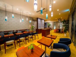 北谷町oile by DSH Resorts的餐厅设有木桌和蓝色椅子