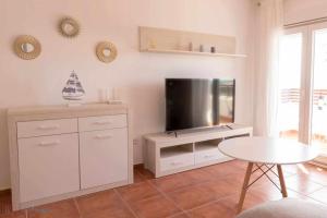 蓬塔翁布里亚Apartamento nuevo junto a la playa vistas al mar的客厅配有电视和桌子