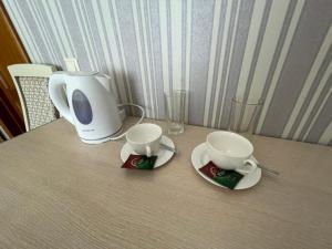 阿斯塔纳Mini-Hotel Sultan的一张桌子,配有两个杯子和咖啡壶