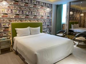 台中市浪琴Motel文创旅馆的卧室配有白色的床和书墙