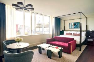 伯明翰The Grand Hotel Birmingham的酒店客房,配有一张床和一张红色的沙发