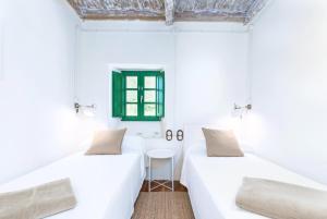 La FocellaTerra Ecoturismo Casa La Casita verde的白色客房的两张床和一张桌子