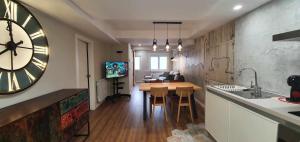 萨拉戈萨Apartamento EL PILAR Céntrico ascensor cocina WIFI en Zaragoza by lodom的厨房配有桌子和墙上的大时钟