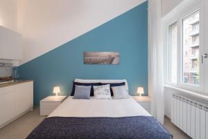 都灵Studio Glicine by Wonderful Italy的蓝色的卧室设有床和窗户