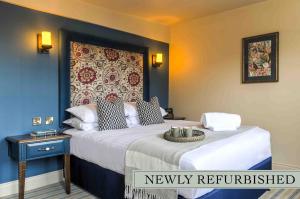 科尔切斯特乔治酒店的一间卧室配有一张床和新装修的床头板