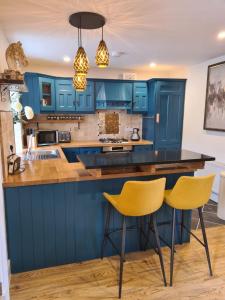 DromodDromod Lodge的厨房配有蓝色橱柜和黄色椅子