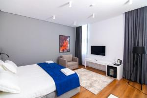 RinasN Hotel BY NOSHI的一间卧室配有一张大床和电视