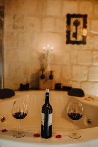 内夫谢希尔Prime Cappadocia Suites的浴缸内的一瓶葡萄酒和两杯酒