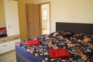 利兴Seeoase Lychen的一间卧室配有一张带两个红色枕头的床
