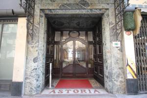 都灵Green Class Hotel Astoria的一座带大木门的建筑的入口