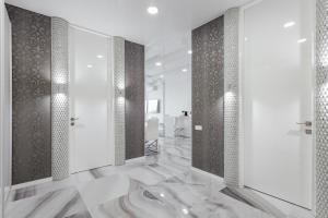 敖德萨皇家公寓的一间铺有大理石地板并设有淋浴间的浴室