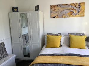 圣奥尔本斯拉吉德厅道住宿加早餐旅馆的一间卧室配有一张带黄色枕头的床和一幅画
