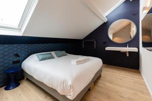 里尔Le Chat Qui Dort - Vieux Lille III的一间卧室配有一张大床和镜子