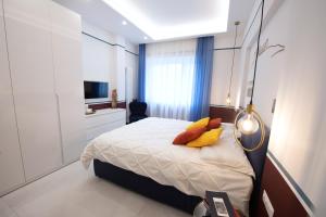那不勒斯Napoli City Center - Appartamenti e Camere的一间卧室配有一张带黄色枕头的床和电视。