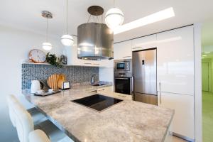 马贝拉Beach Front Apartment-1st Line的厨房配有大型大理石台面和电器